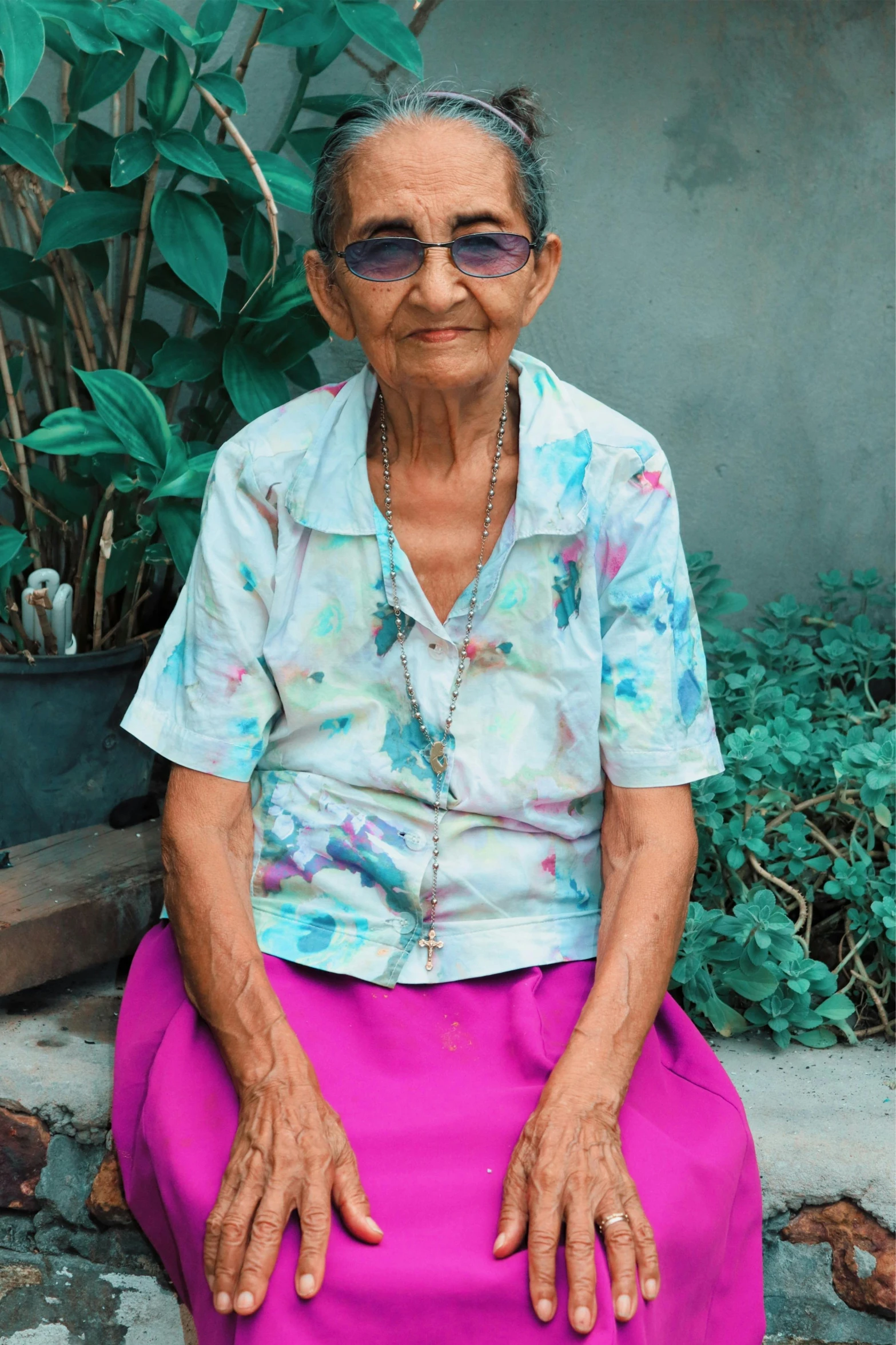 an older woman sitting in a flowery garden