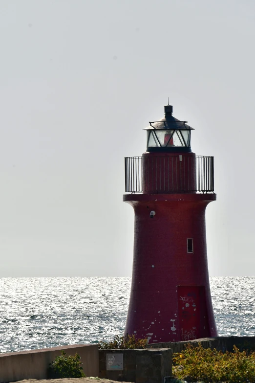 a light tower on a clear day by the water