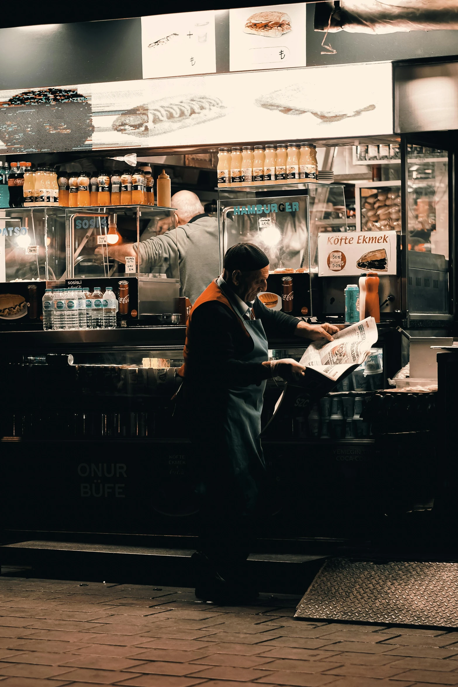 the man sits at the counter in front of the food cart