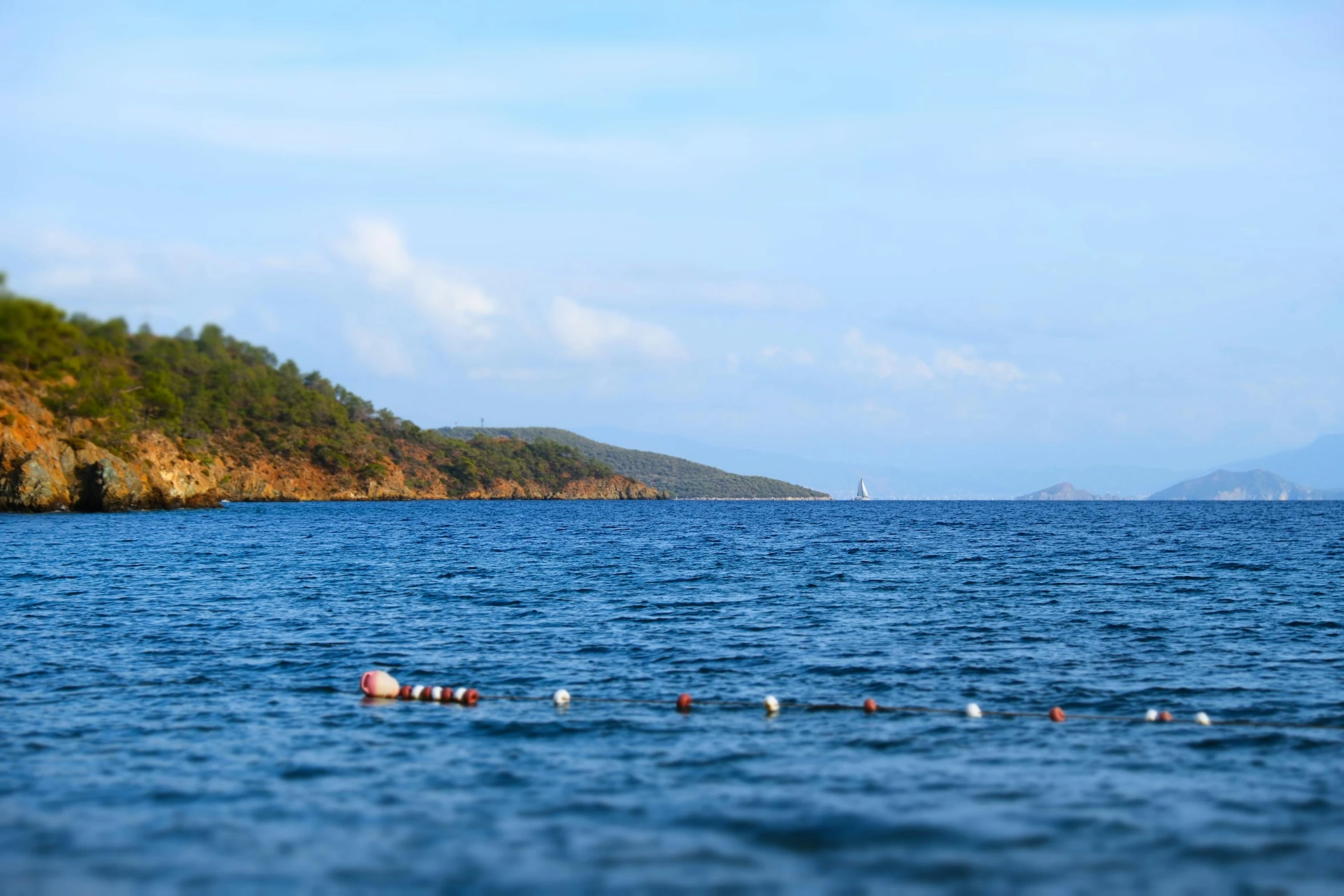 many sea containers floating in the water on the side of the hill