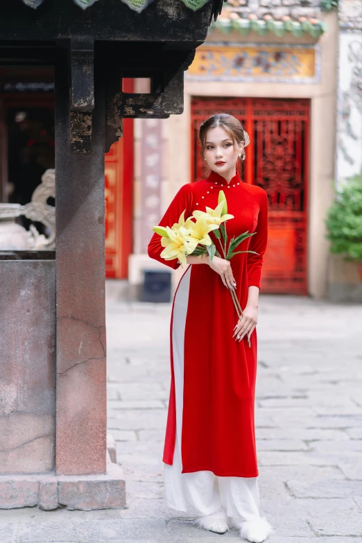 a woman in a red coat holding flowers