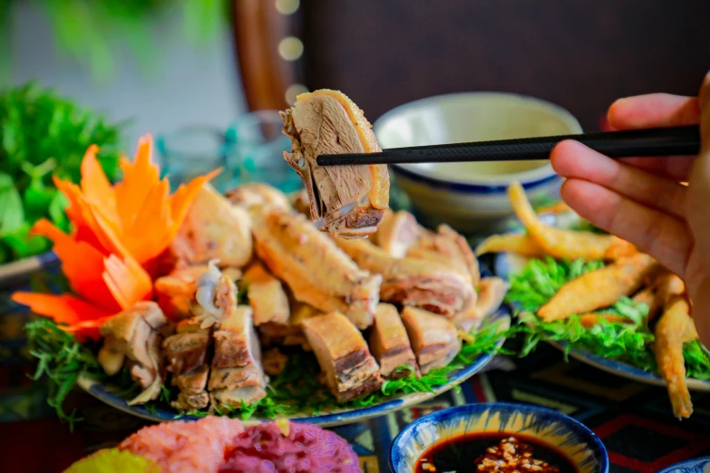 a person holding chop sticks over an assortment of food