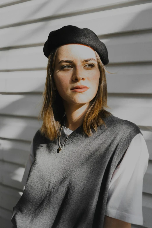 young woman wearing black hat and grey shirt looking ahead