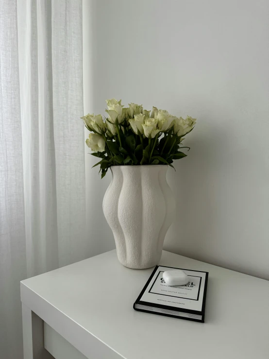 a white vase with some flowers in it