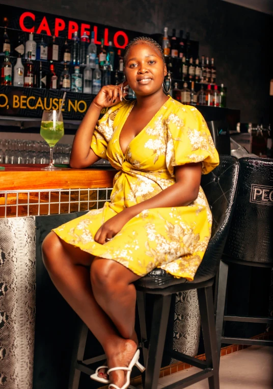 a woman wearing a yellow dress sitting in a chair