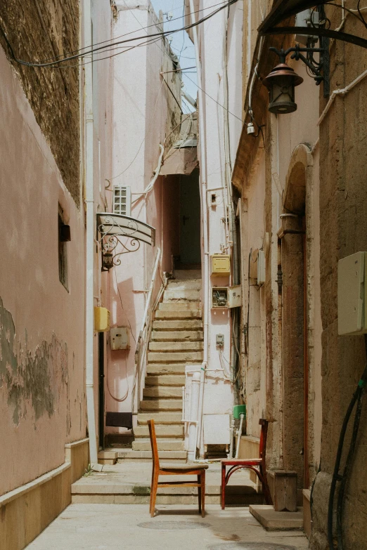 a very narrow city street with steps that are next to a stairwell