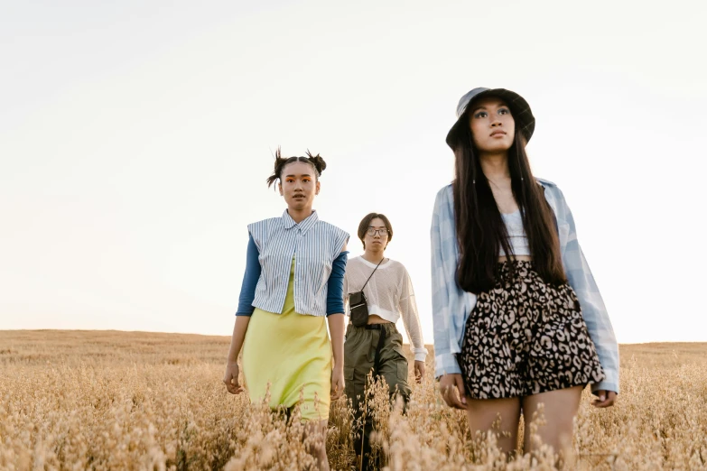 three people standing in the middle of a field