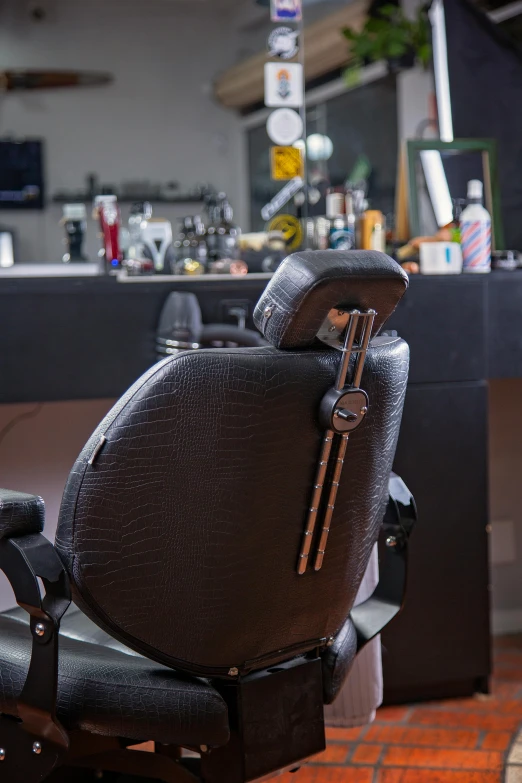 the back end of a brown and black chair in a salon