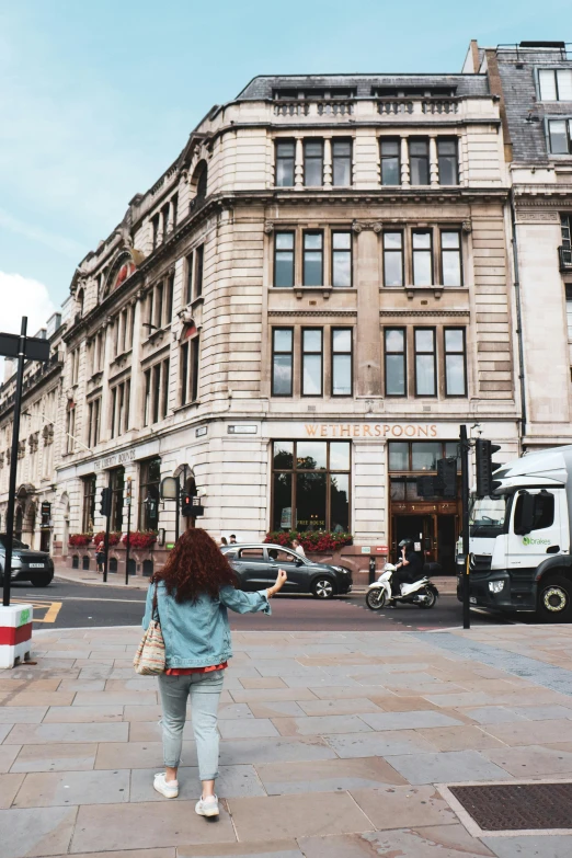 a woman is walking in the street with her hand in the air