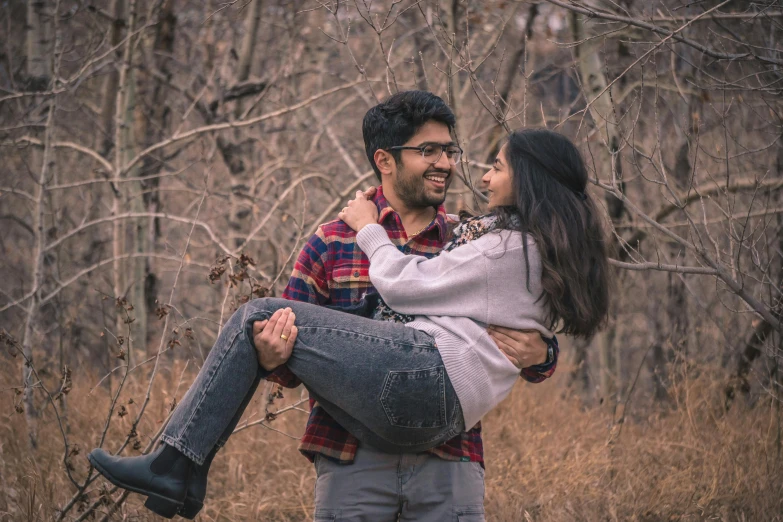 a woman carrying a man in the forest