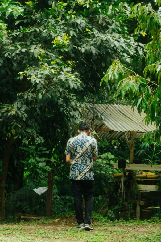 a man standing in front of a forest with trees