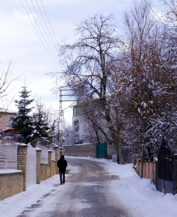 a person walking down a road in the snow