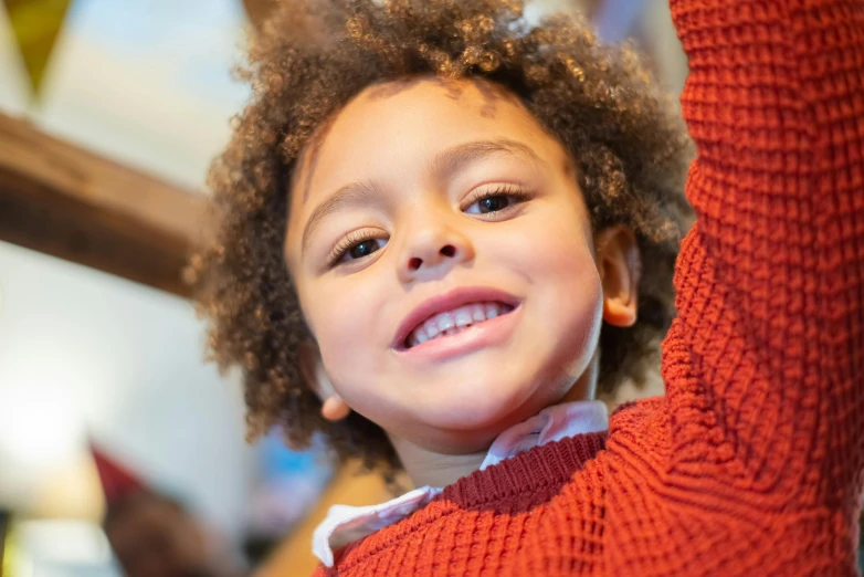 a little girl is holding her arm up with the other hand