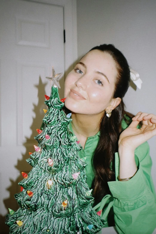 a woman looking at a decorated tree with decorations