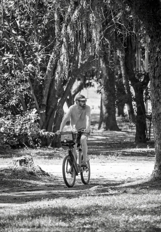 a man riding a bike through a park