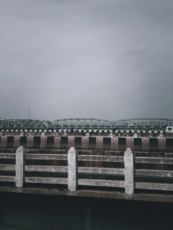 a bench next to a rail and a bridge