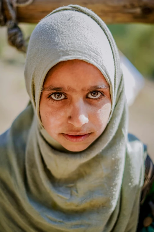 a woman in a headscarf looking into the camera