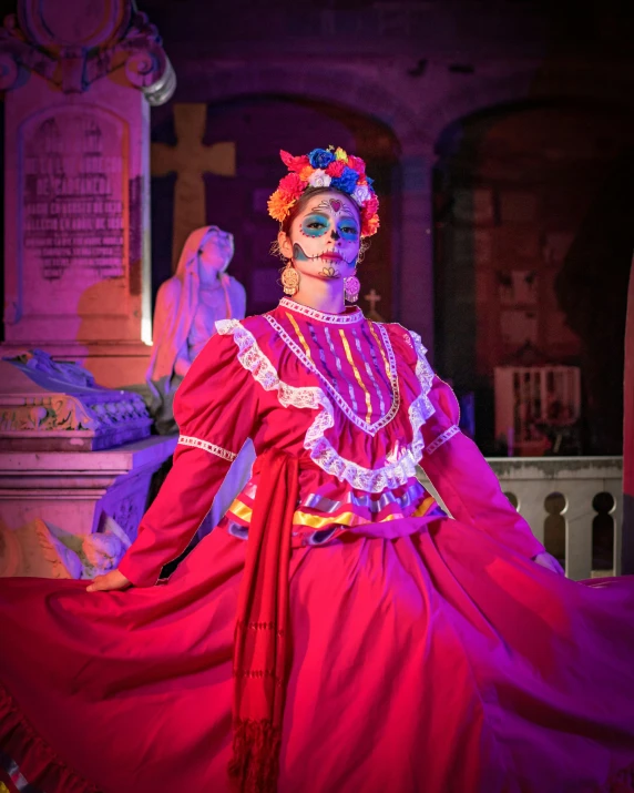 the costumed woman is wearing a colorful headpiece and large flowers in her hair