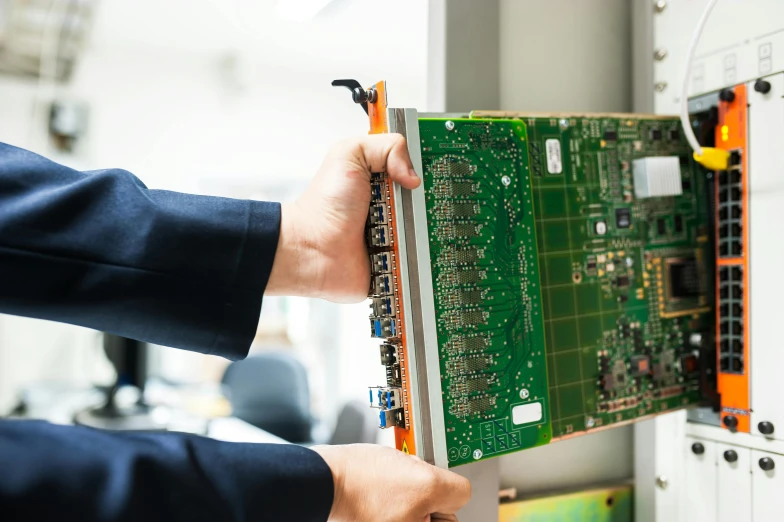 a man assembling a server board from a rack in his server room