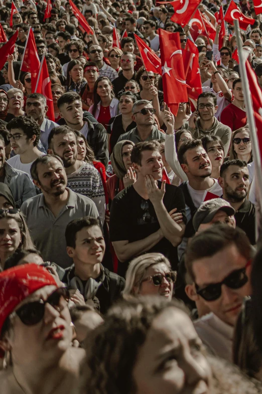 many people are standing together holding flags and flags