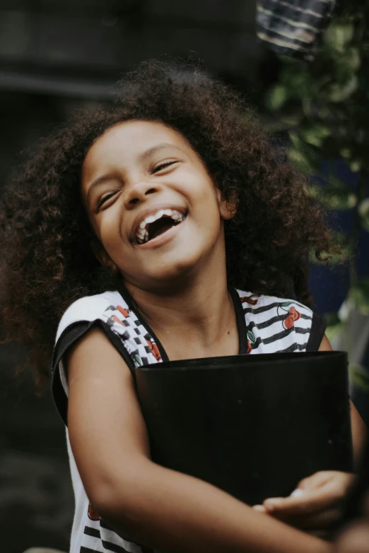 a girl laughs while holding an instrument in her hands