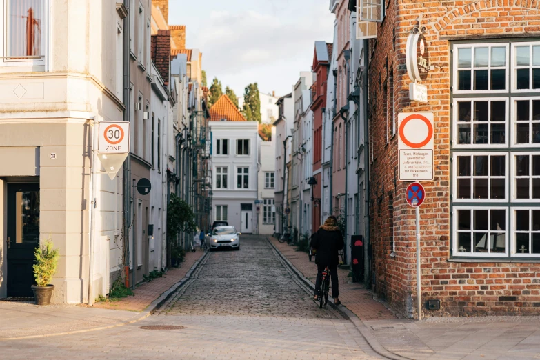 a car driving past a man on a bicycle