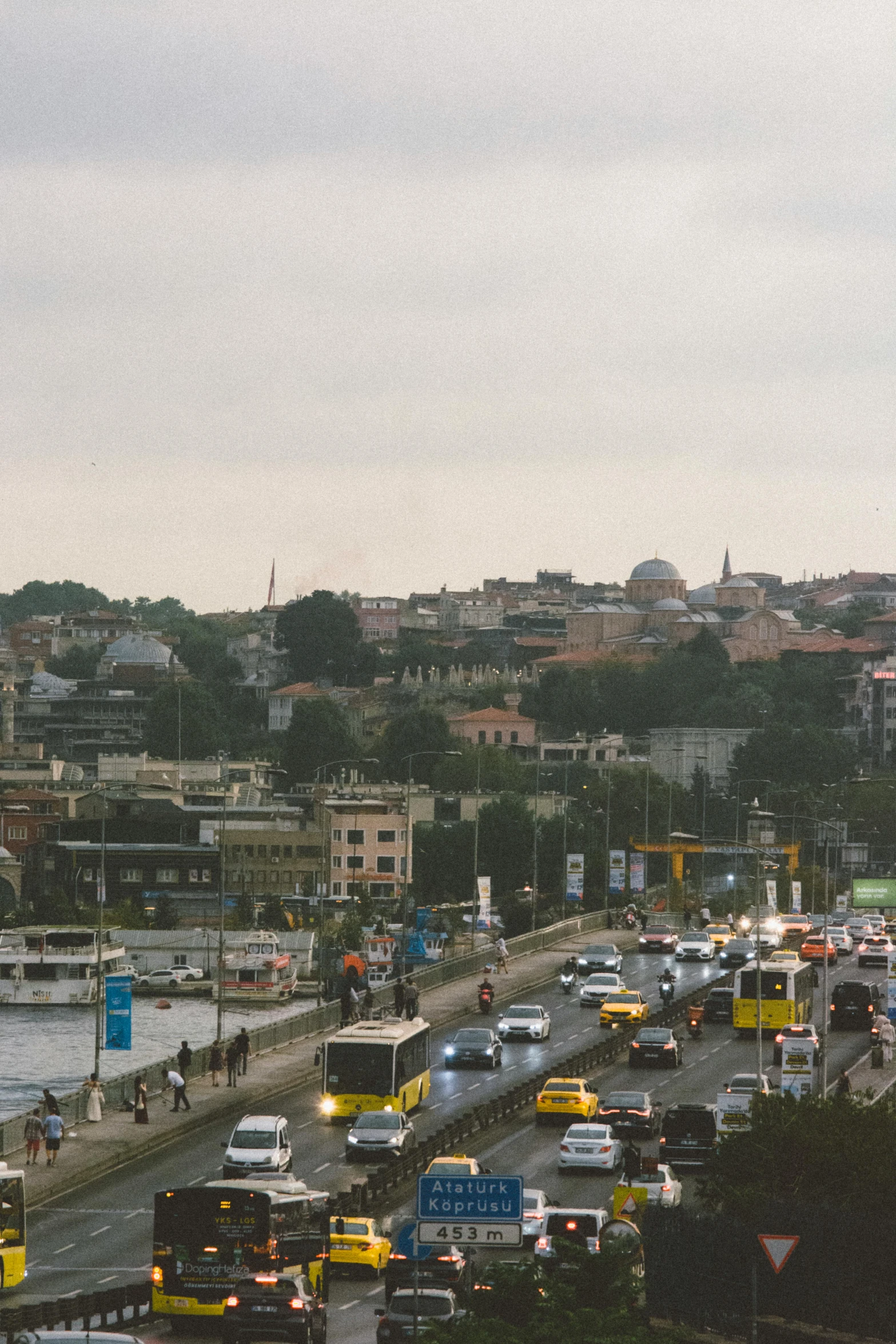 the crowded street is filled with cars and buses