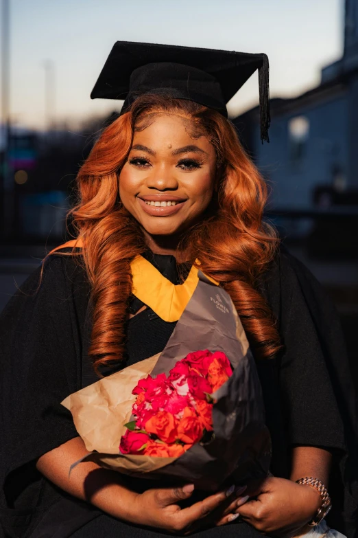 a woman in a graduation gown holding flowers