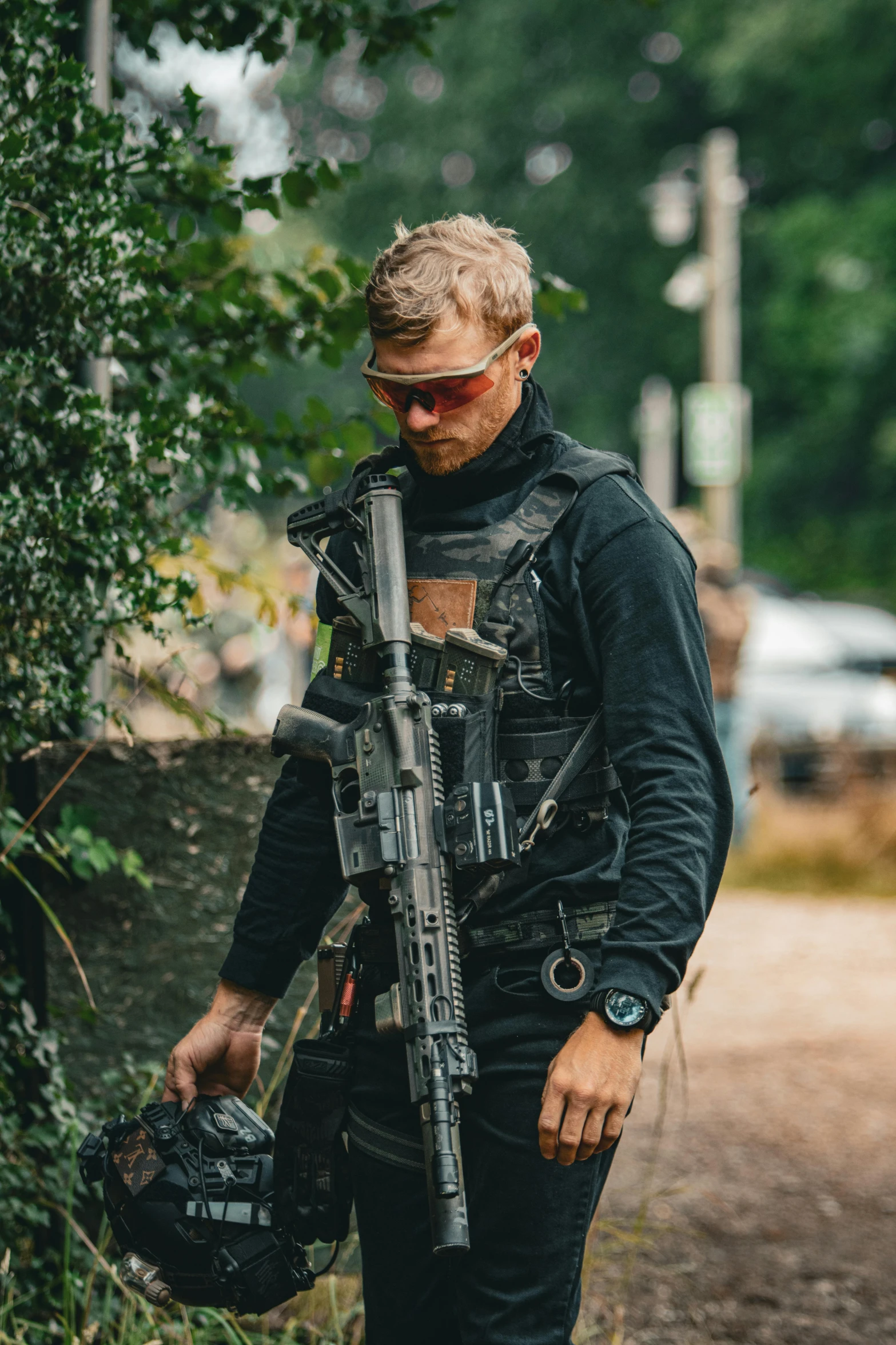 a man holding a machine gun on top of a forest