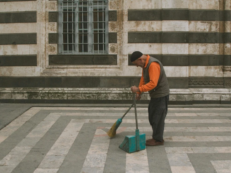 a man sweeping the street with two brooms