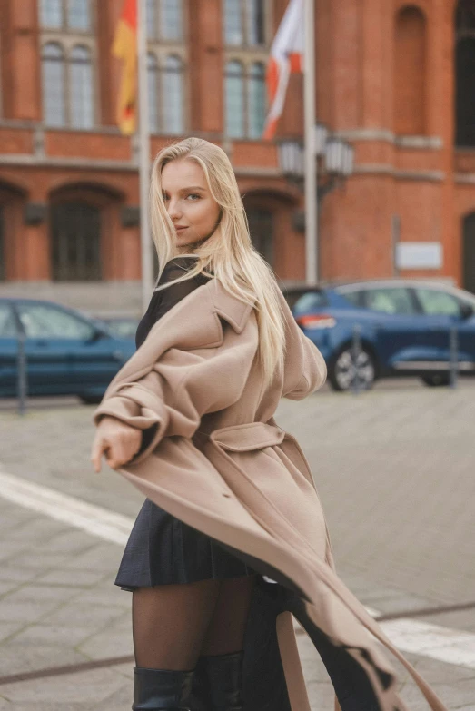 a woman posing outside in an over the knee coat