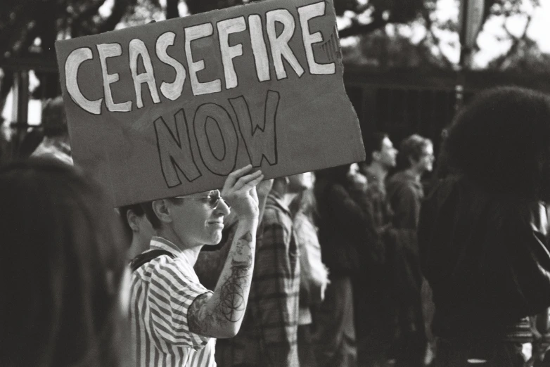 a  holding a sign while people stand around him