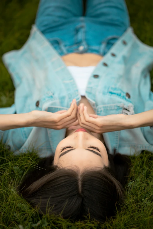 woman laying on grass with her hands in the air