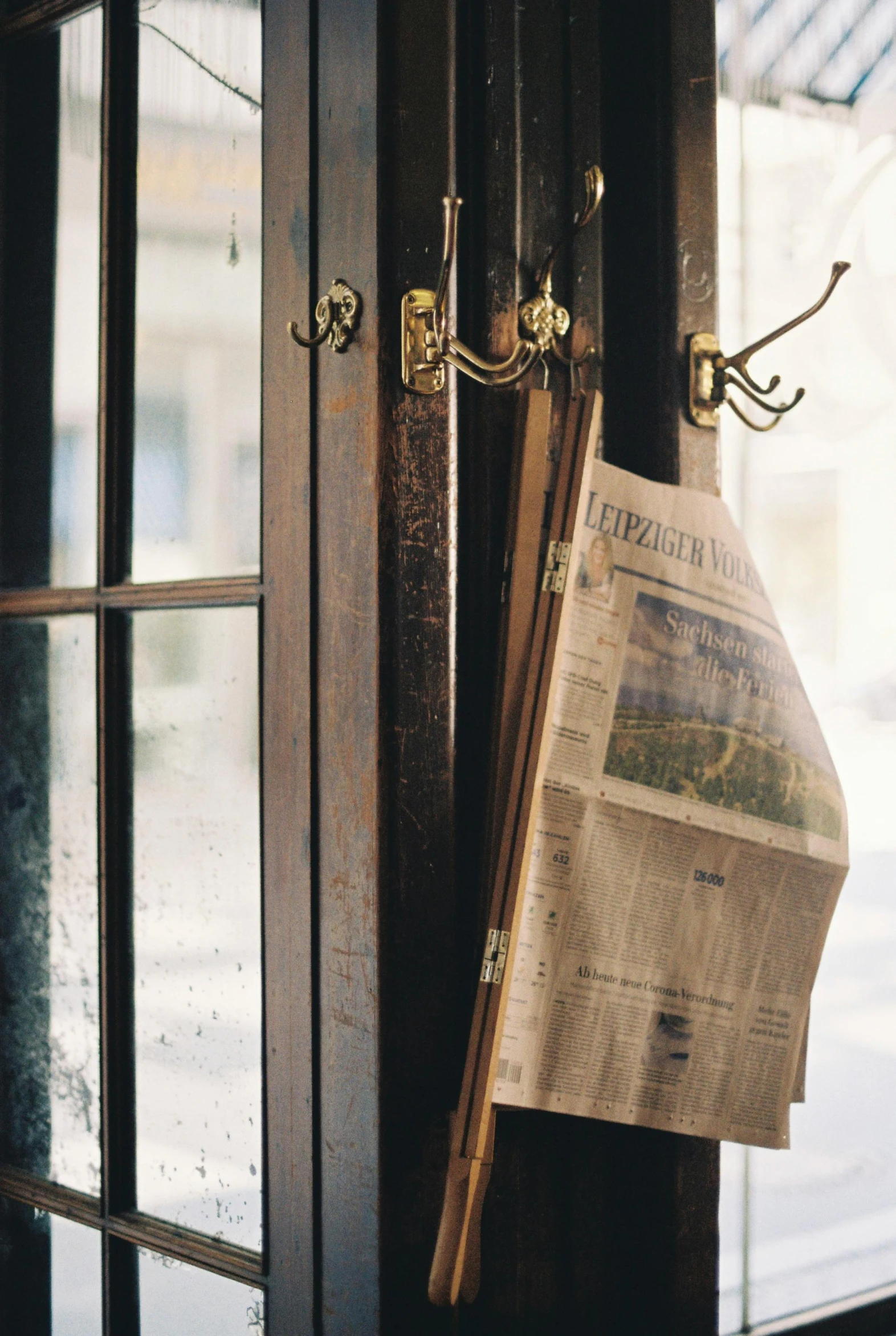 an old newspaper is hanging in the front door of a house