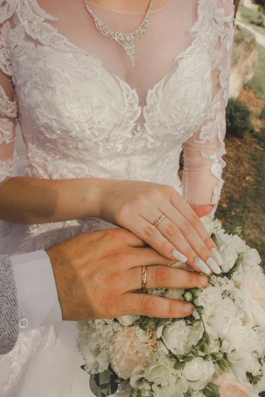 a close up of two people with wedding rings on their hands