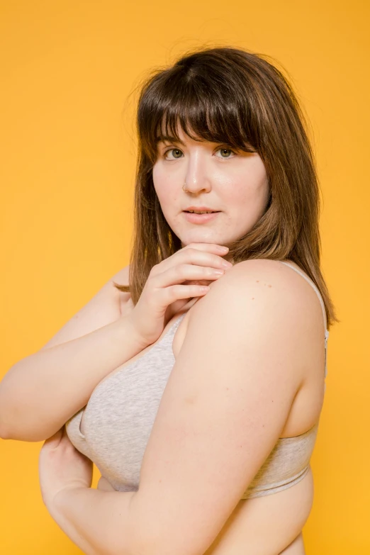 a woman in a grey tank top posing for the camera