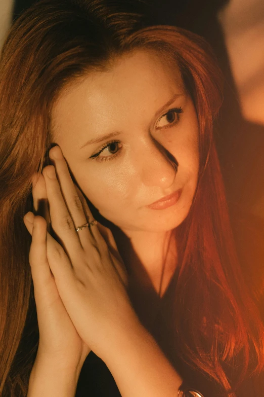 a pretty young lady posing with her hands clasped