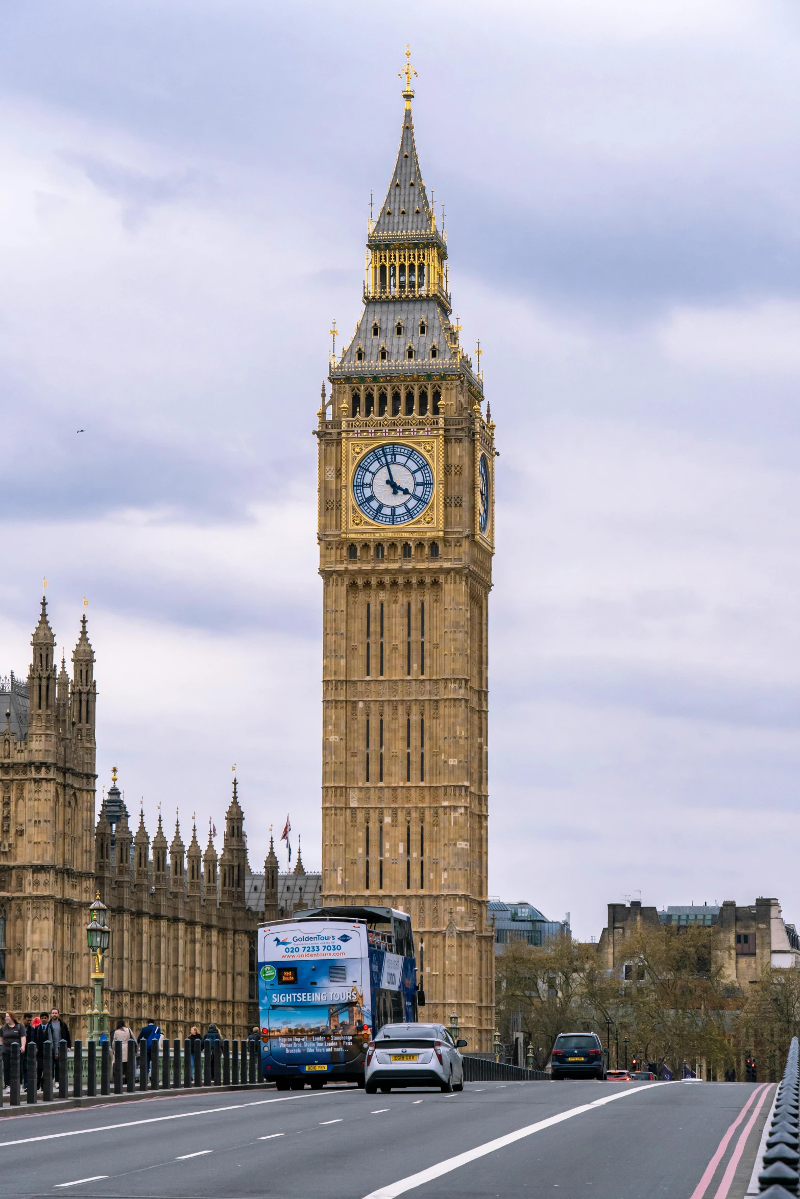 a blue bus is driving near a large building