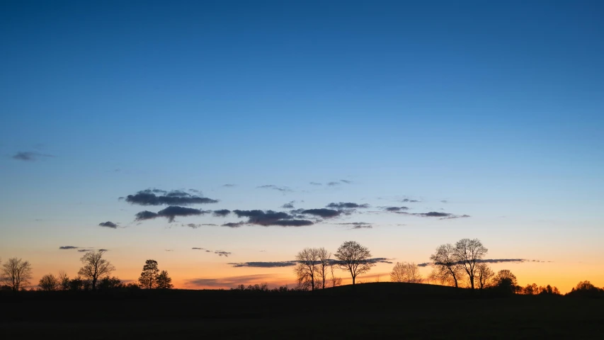 an airplane flies high in the sky over a field