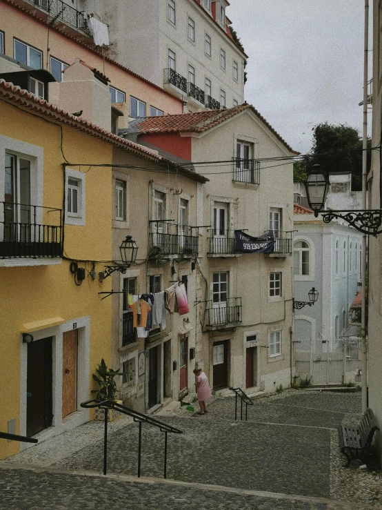 a cobble stone street with multiple buildings and balcony railings