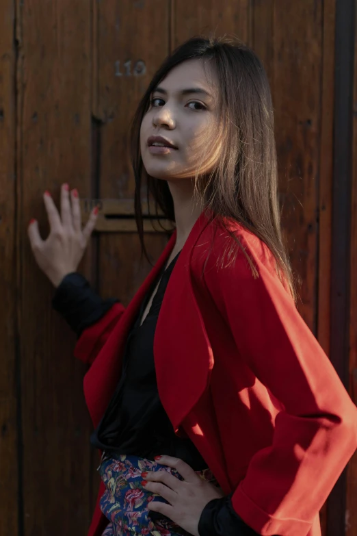 the woman is wearing a red jacket with a black top