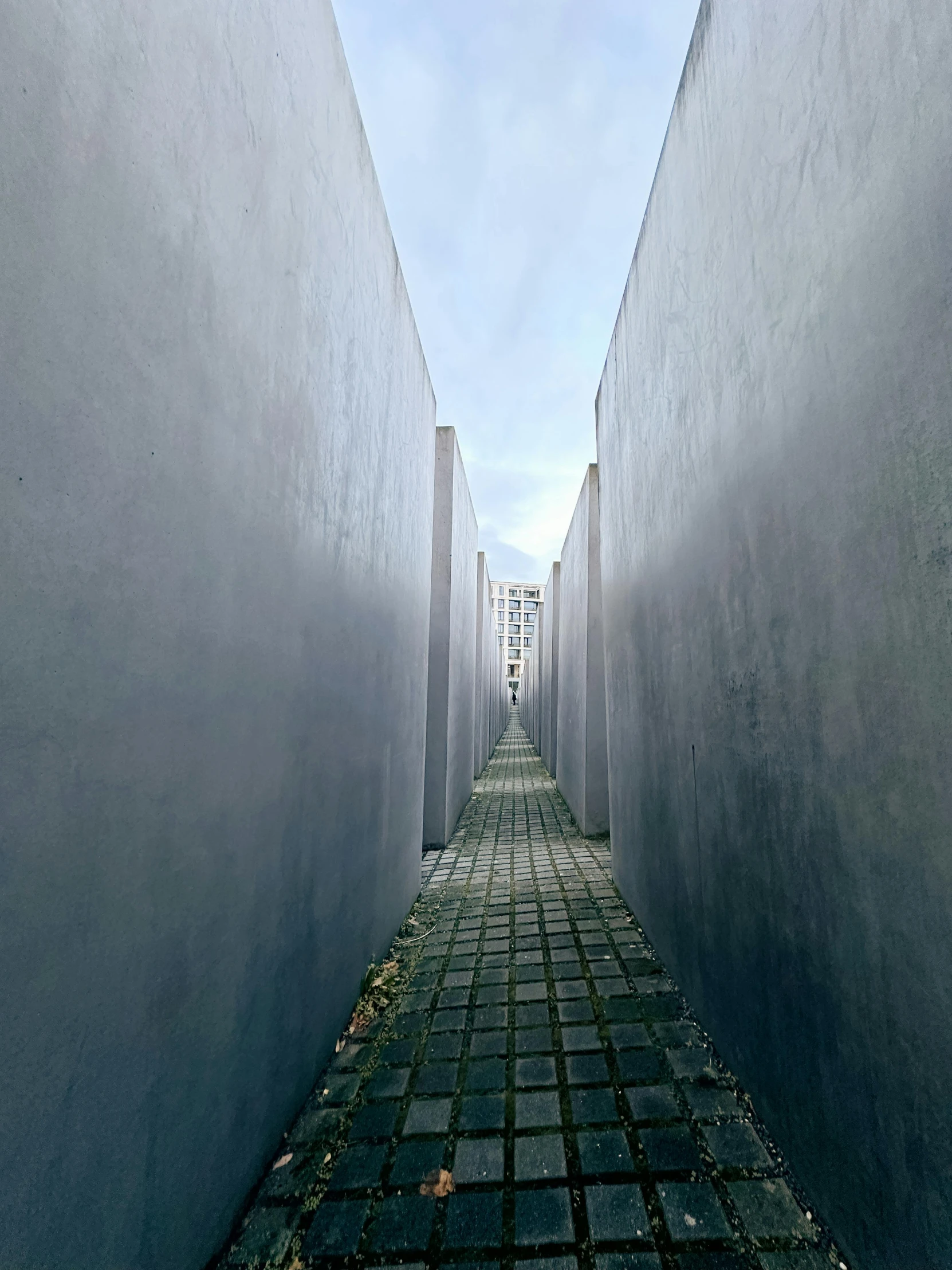 the walkway between the concrete walls leads to the sky