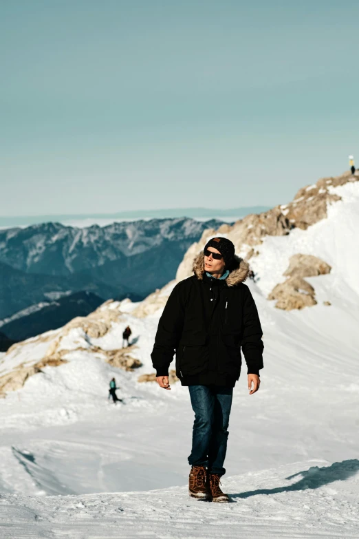 a man standing on top of a snow covered slope