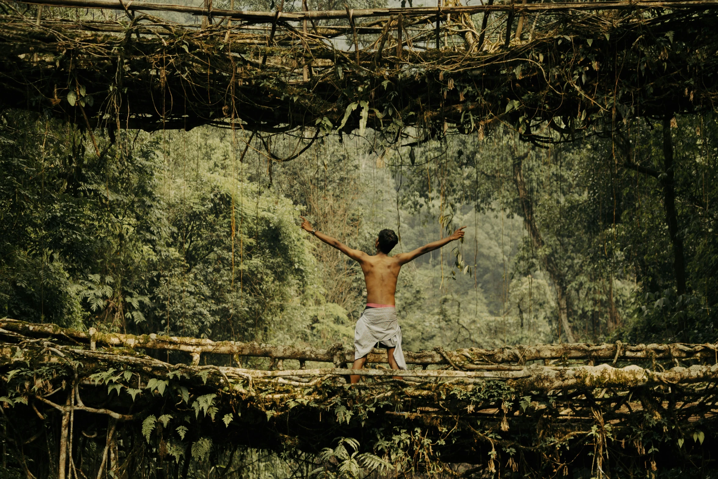 a man stands on a bridge made of nches