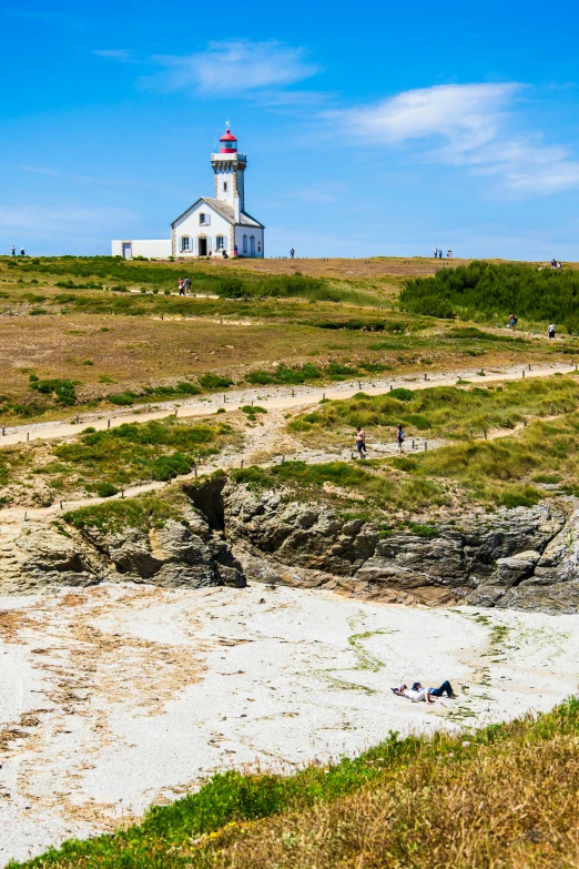 a lighthouse on the shore is shown from a distance