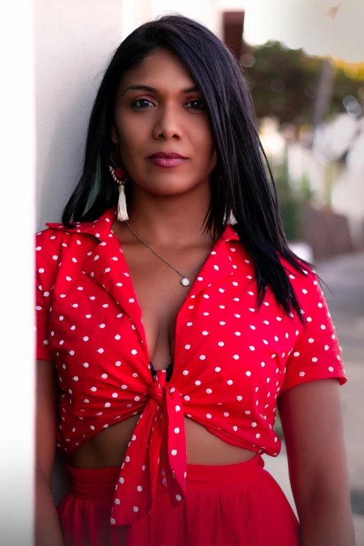 a woman is wearing a red top and posing for the camera