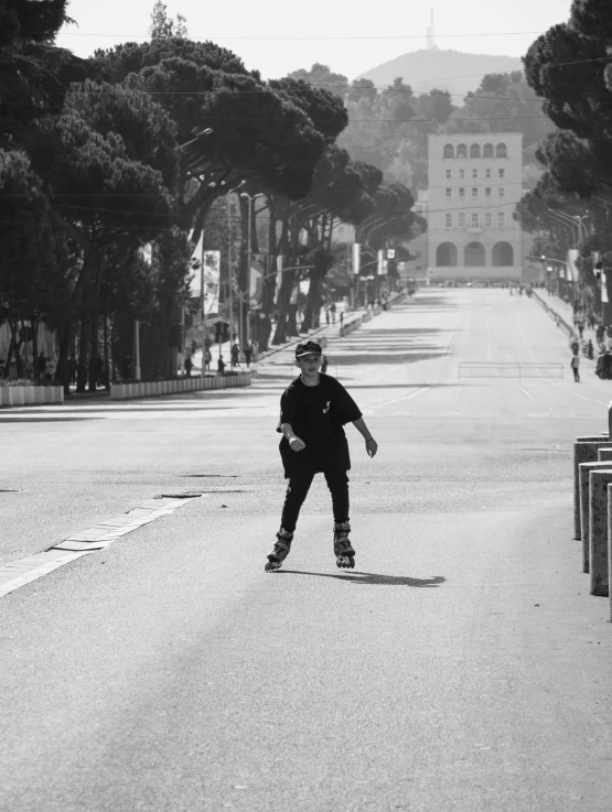 skateboarder on street near buildings in black and white po