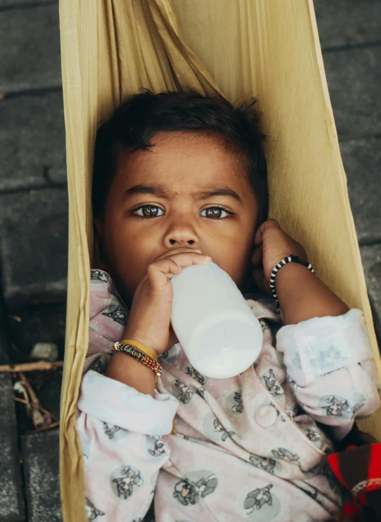 a young child drinks milk from a bottle