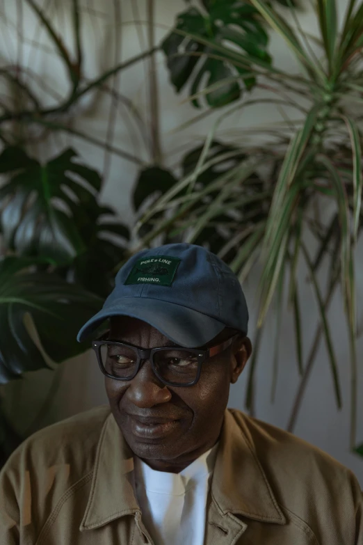 the black man is sitting near large plants