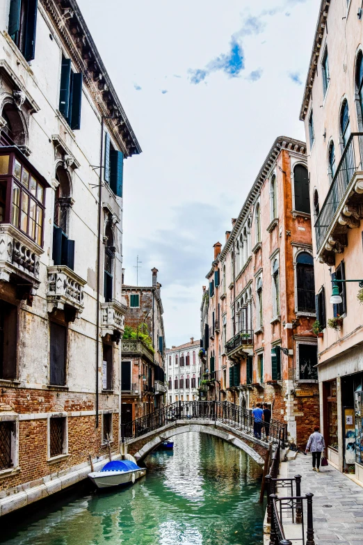 a narrow street with small buildings and canals in venice